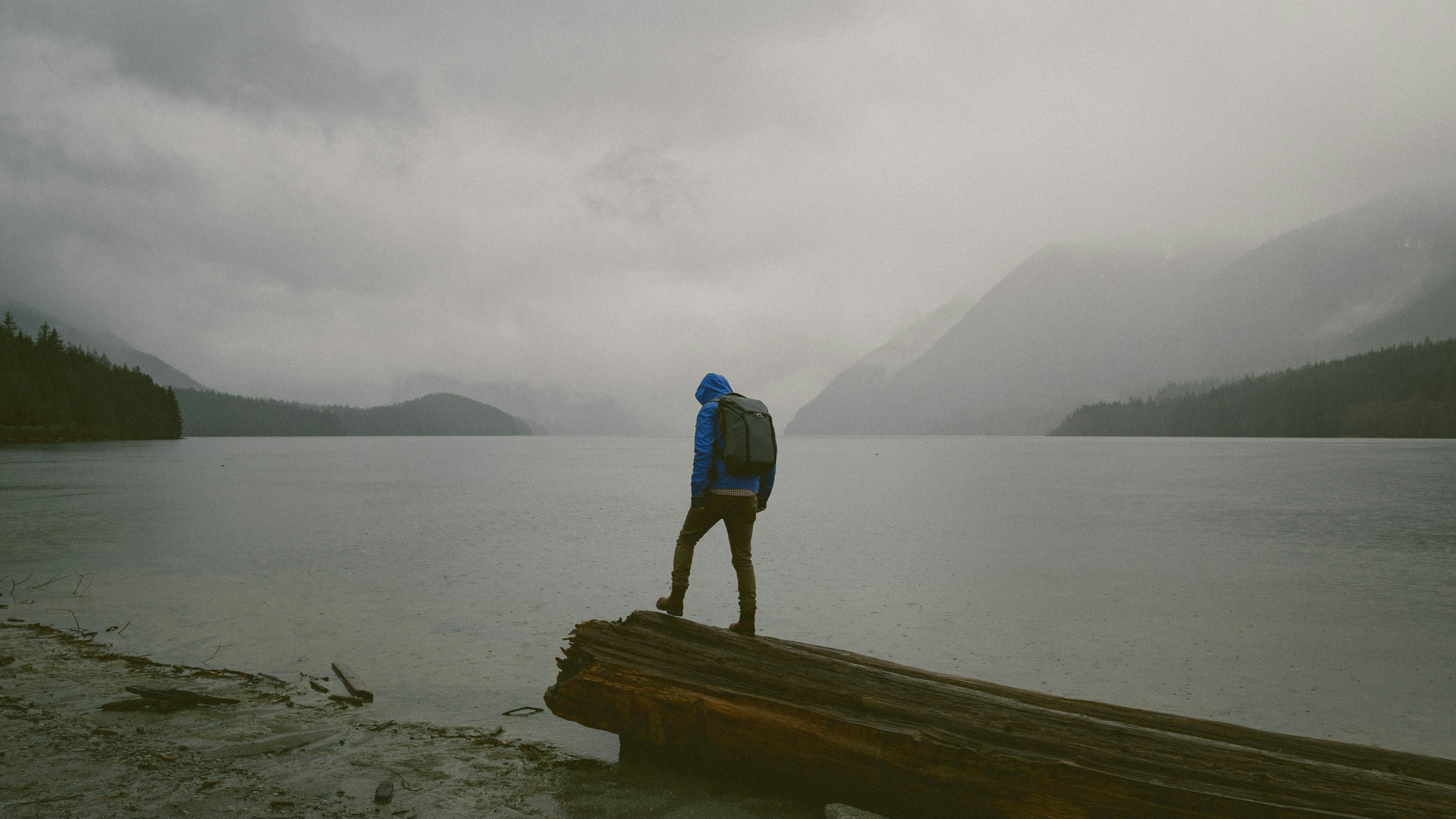 man standing on wooden platform in front of water during daytime